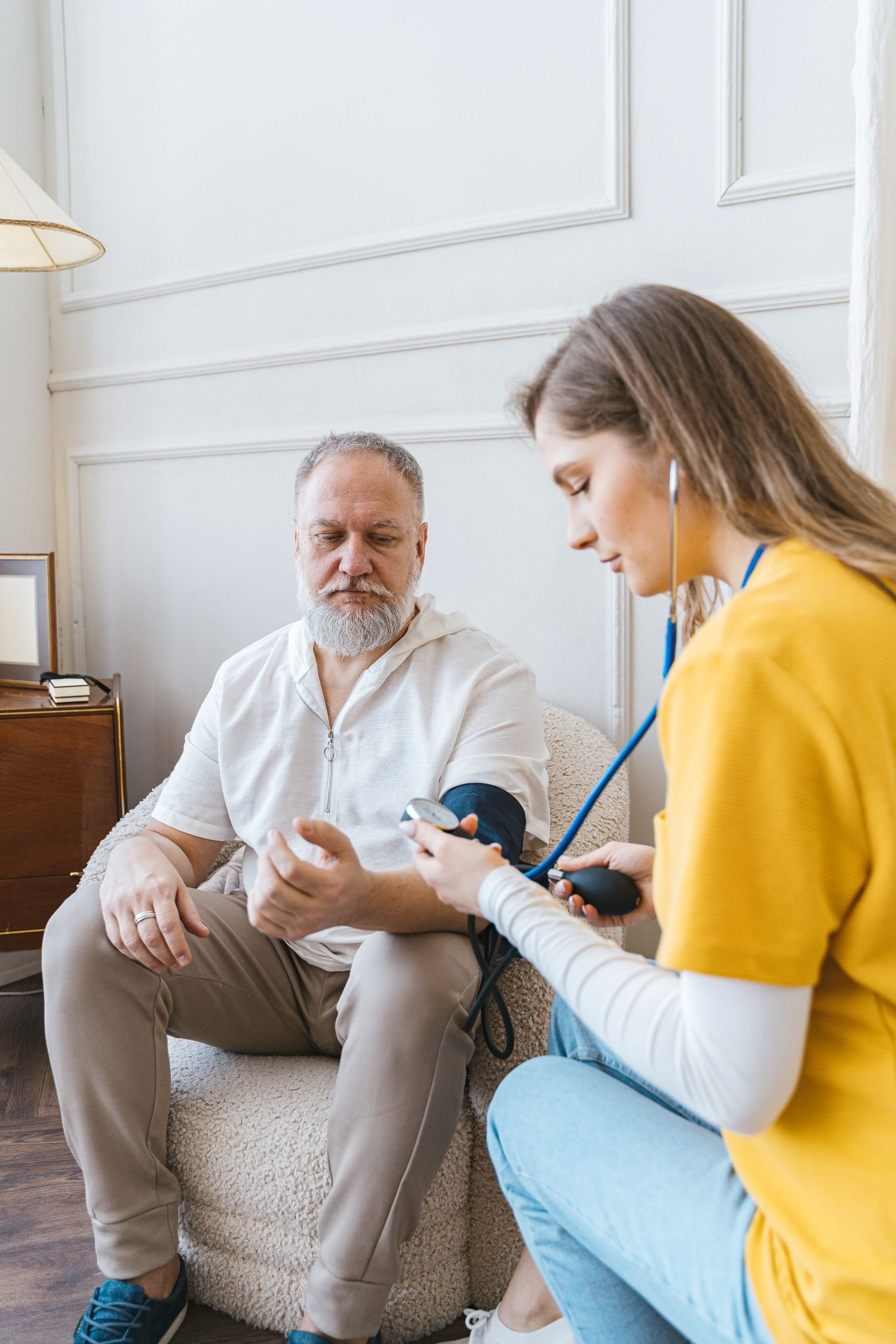Nurse checking an older man's blood pressure at his appointment