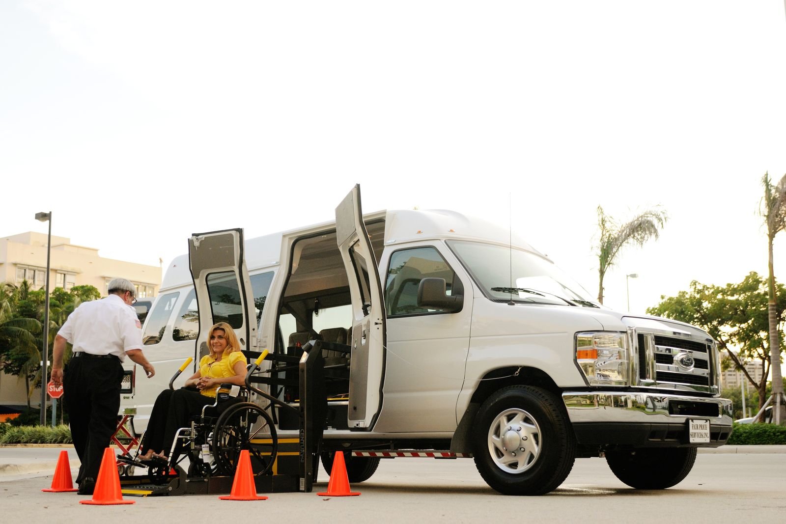 Driver assisting a wheelchair passenger onto an accessible van ramp